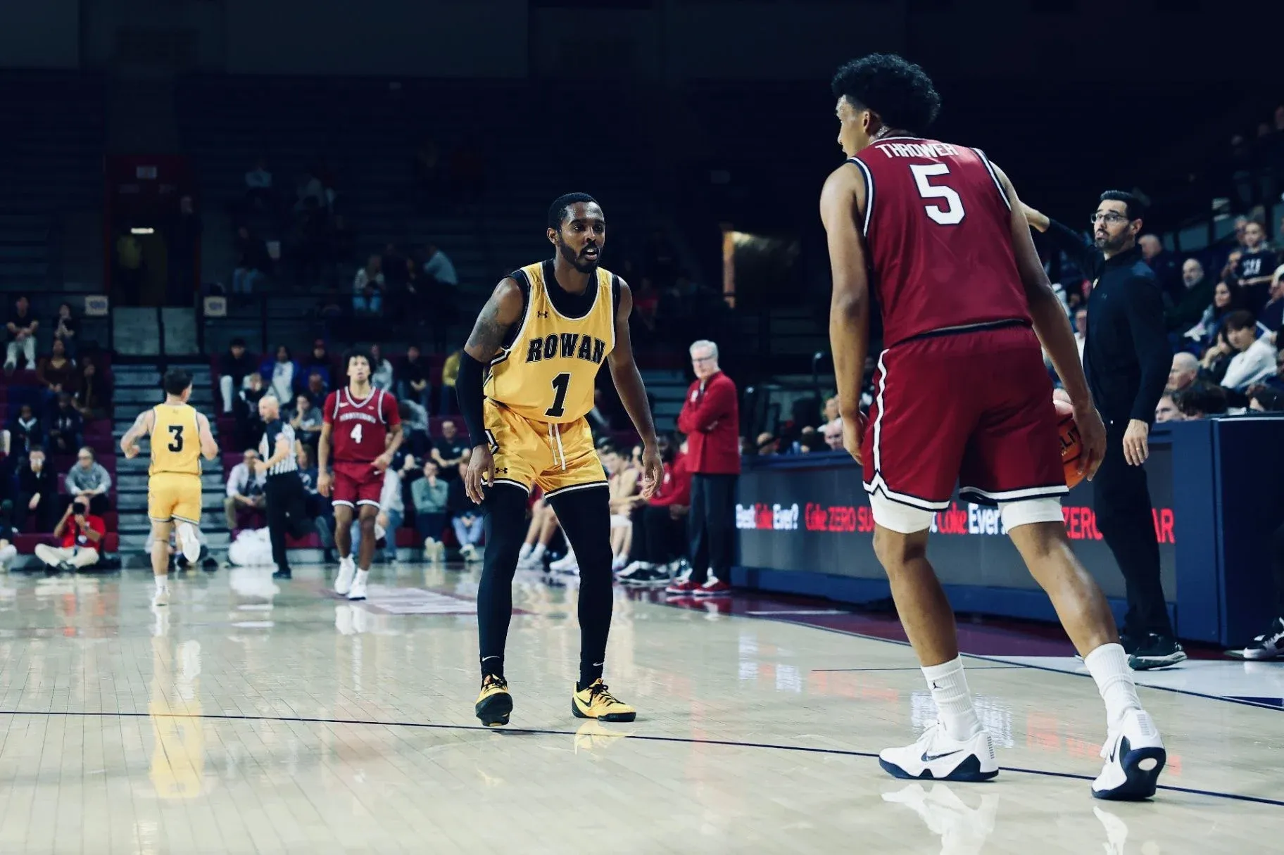 Fareed Burton Jr. holding a defensive stance in a gold Rowan College jersey